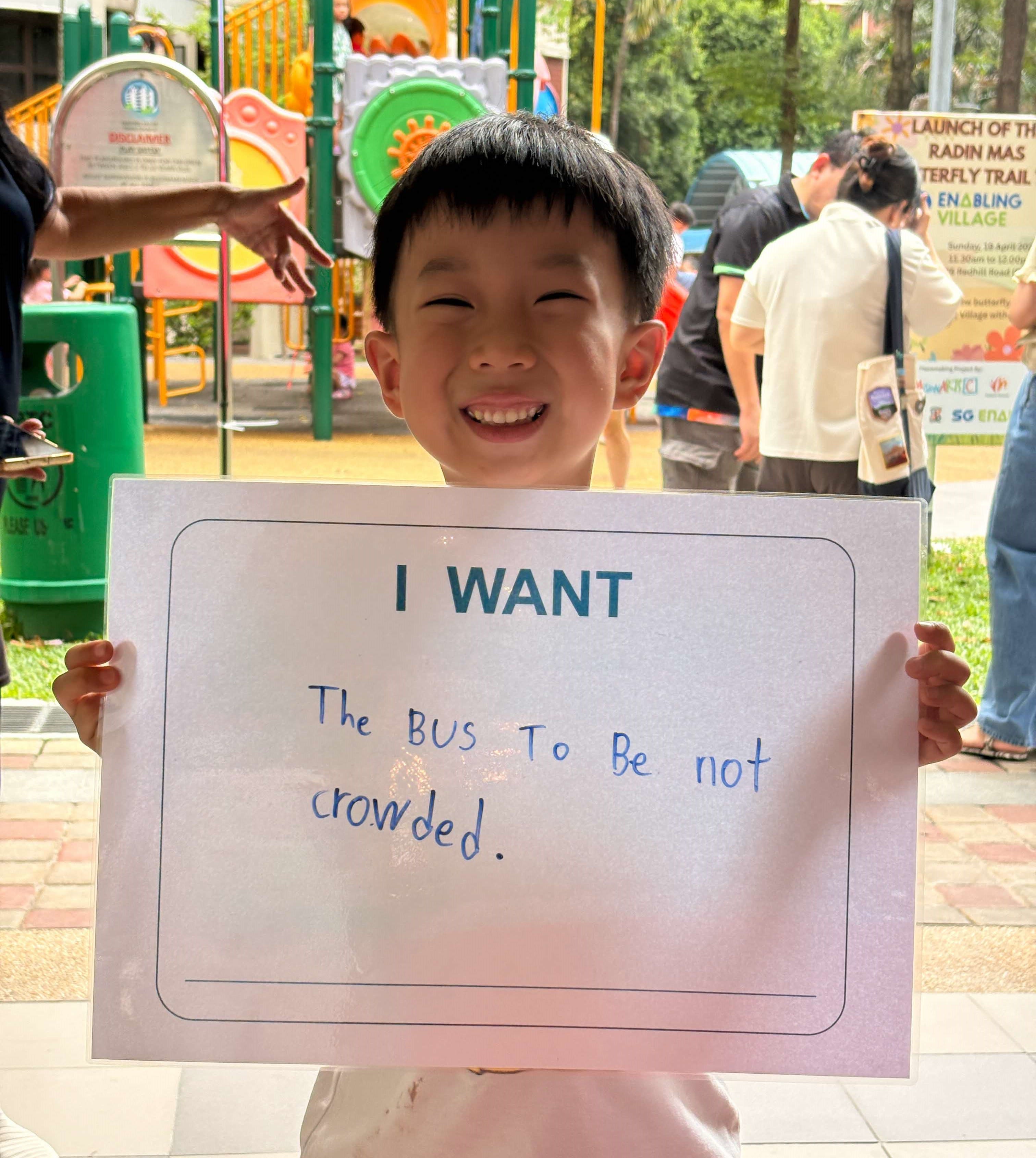 Image of young boy holding a placard of his transport aspirations
